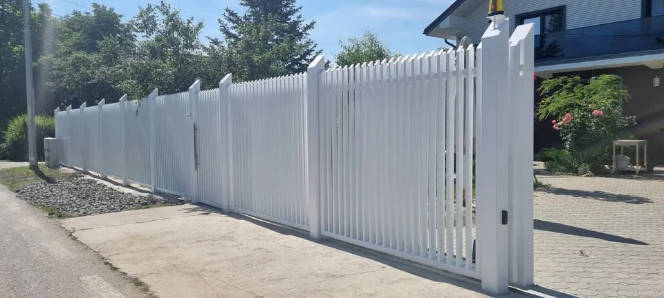 Gard alb din profile metalice verticale, cu poartă culisantă