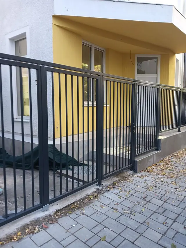 Gard cu bare verticale și portiță, clădire nouă