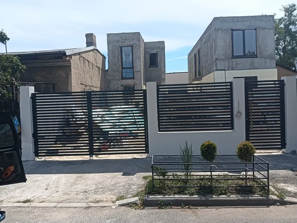 Gard cu lamele orizontale și jardiniere metalice