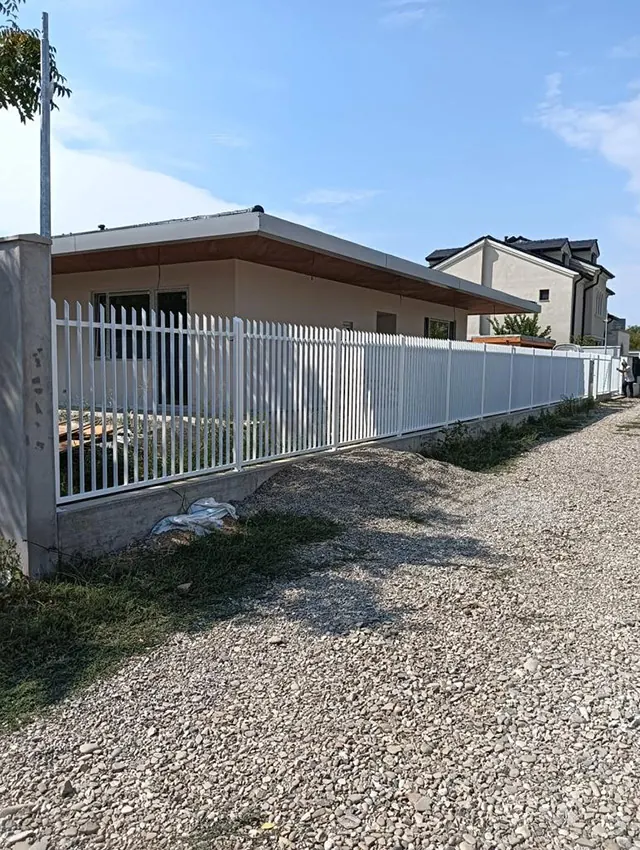 Gard alb din profile metalice verticale pe soclu