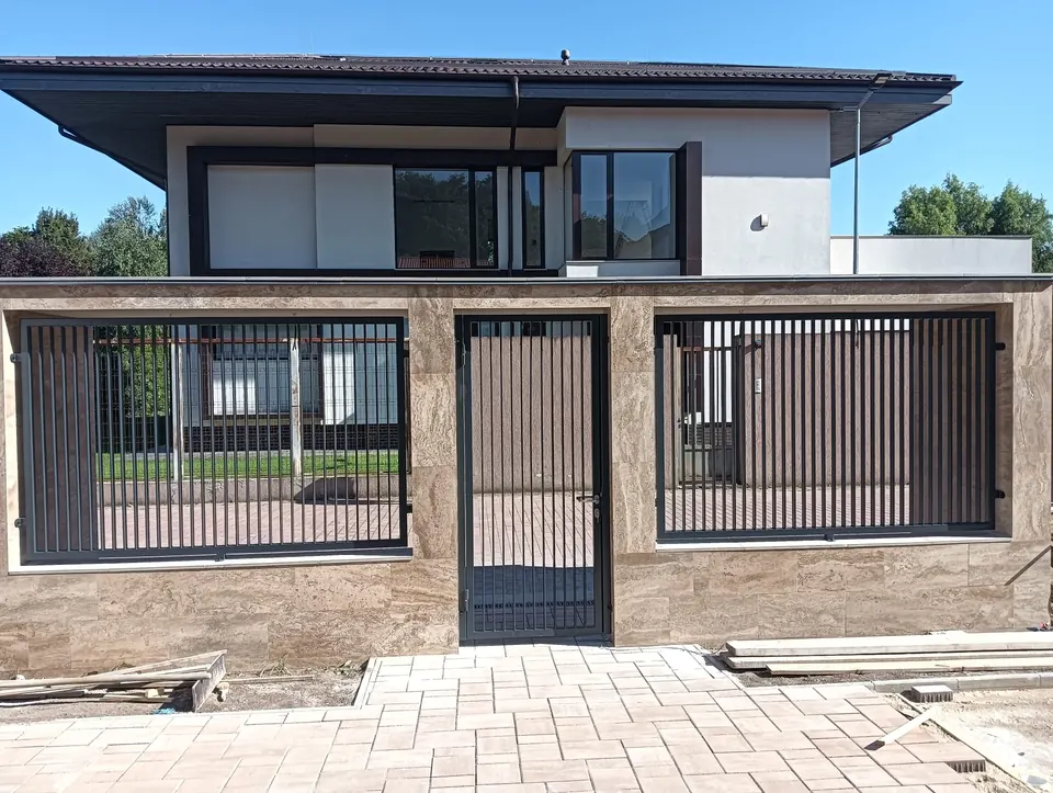 Gard cu bare verticale pe soclu placat cu piatră